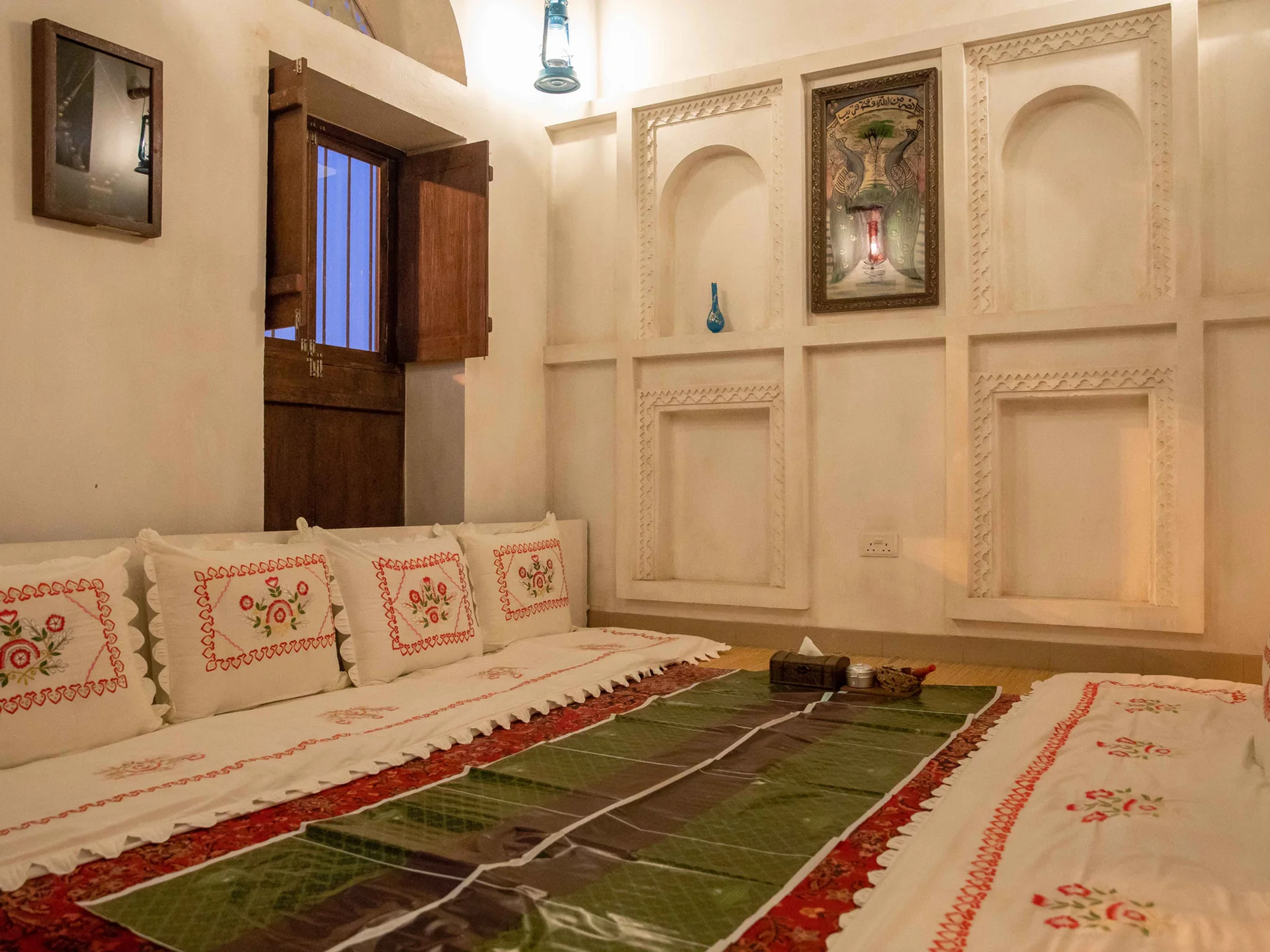 فرع العين: مجلس بجلسات أرضية ووسائد مطرّزة بالأحمر